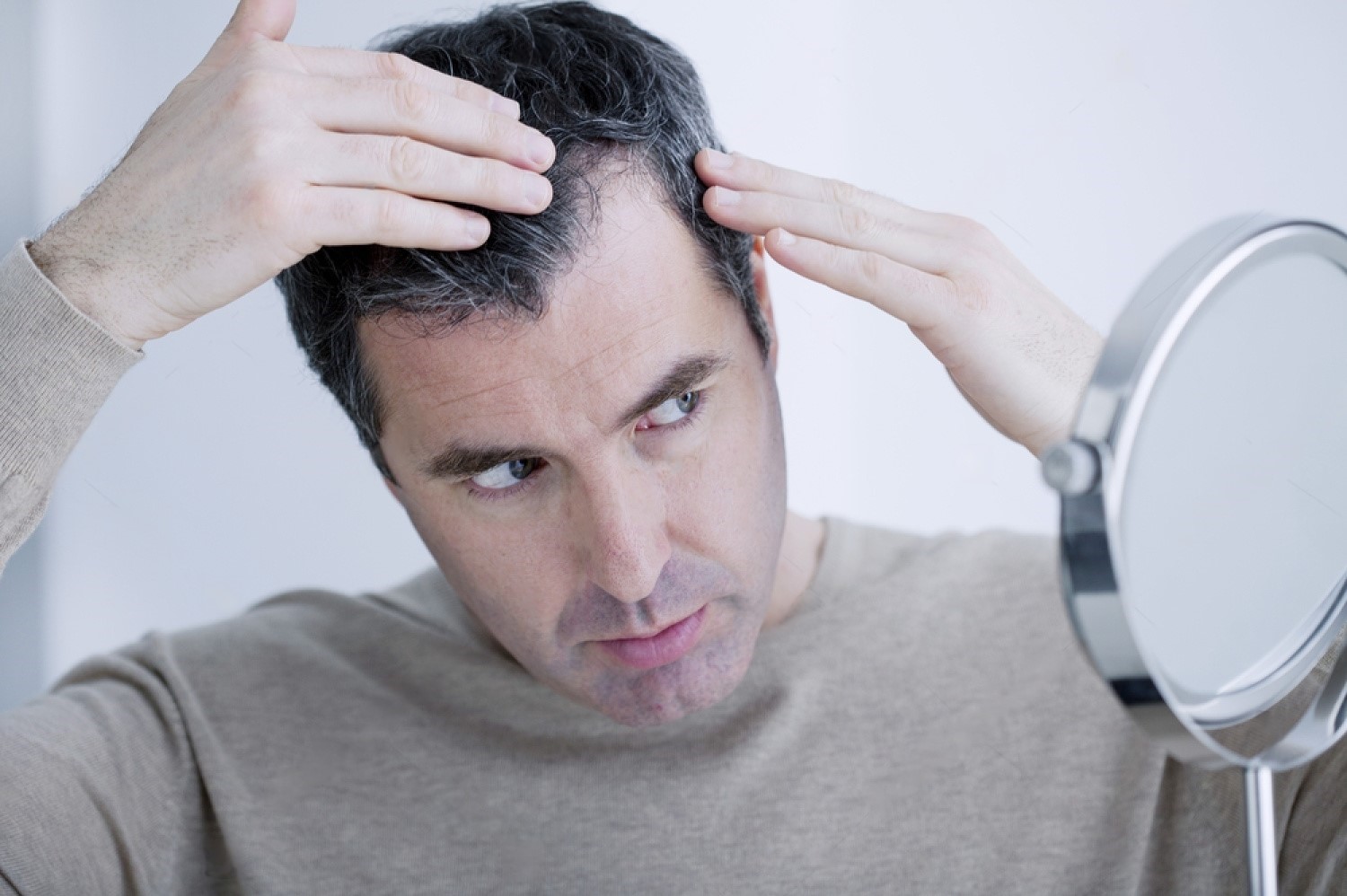 Man checking hair fall in mirror